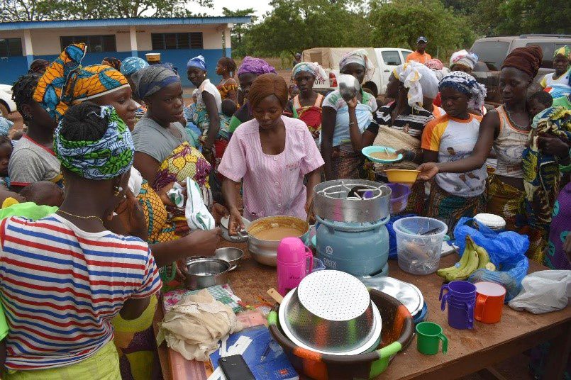 Porridge is ladled into bowls for children