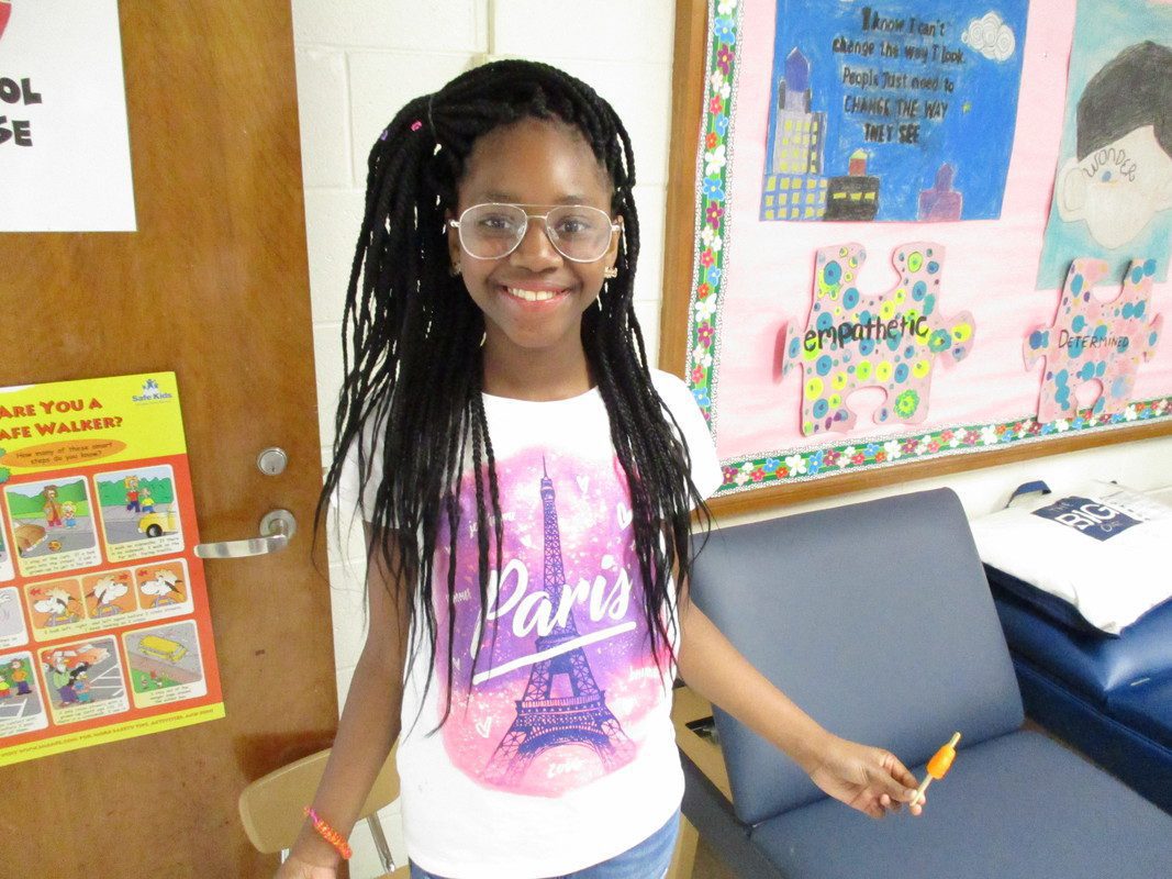 A young girl smiles while wearing her new eyeglasses