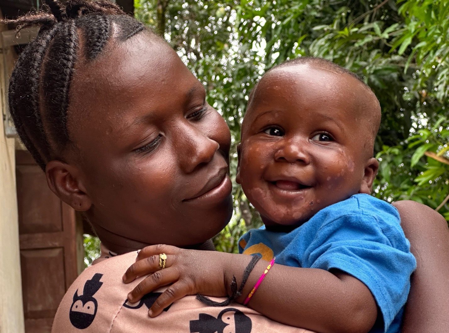 Smiling mother holds her baby.