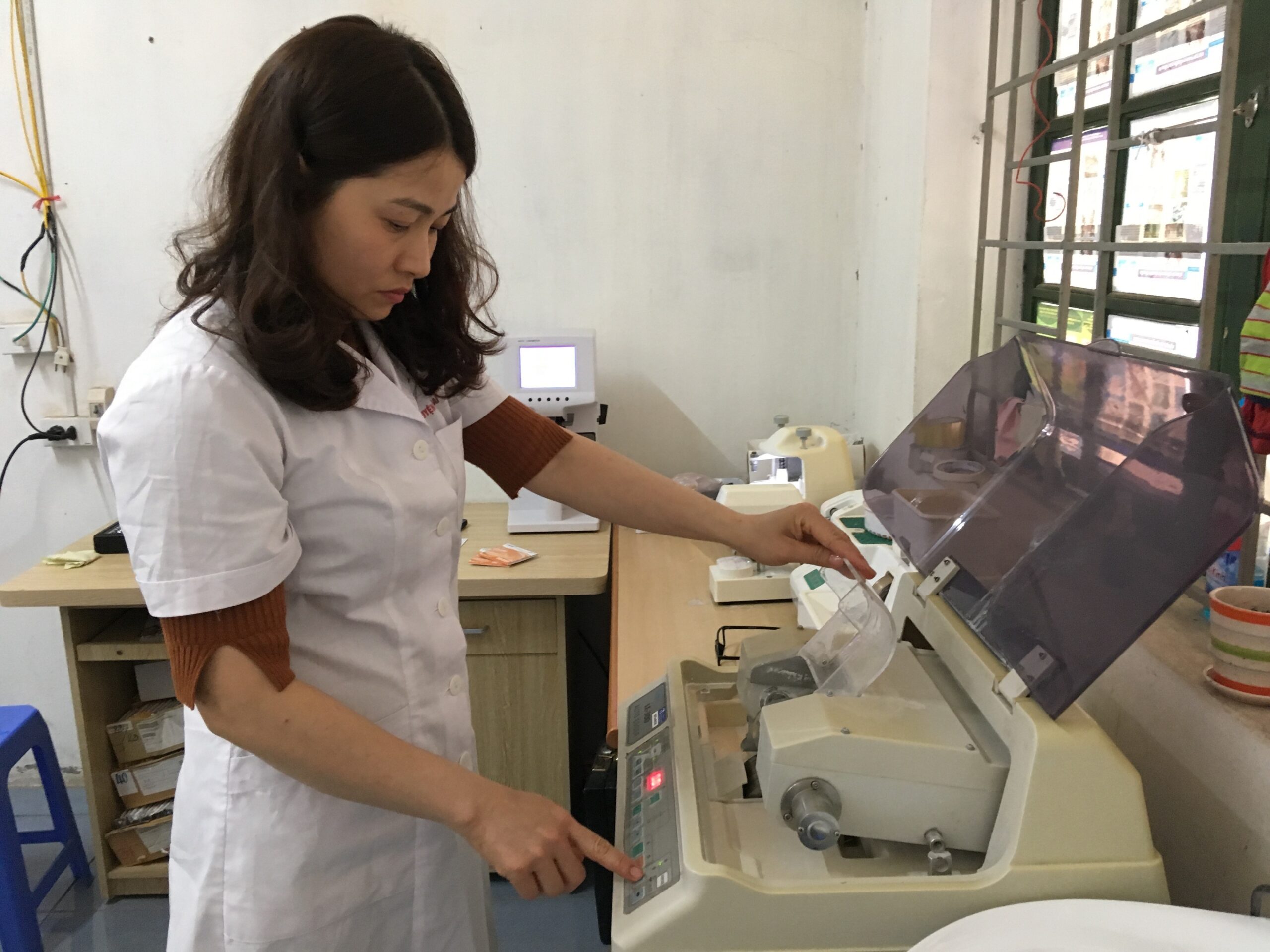 Ngoc pushing buttons and entering measurements into a machine