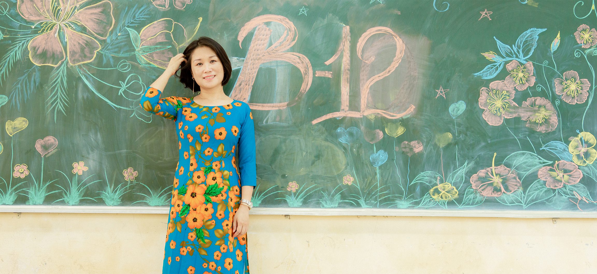 Pham Kim Ngoc stands in front of a chalkboard