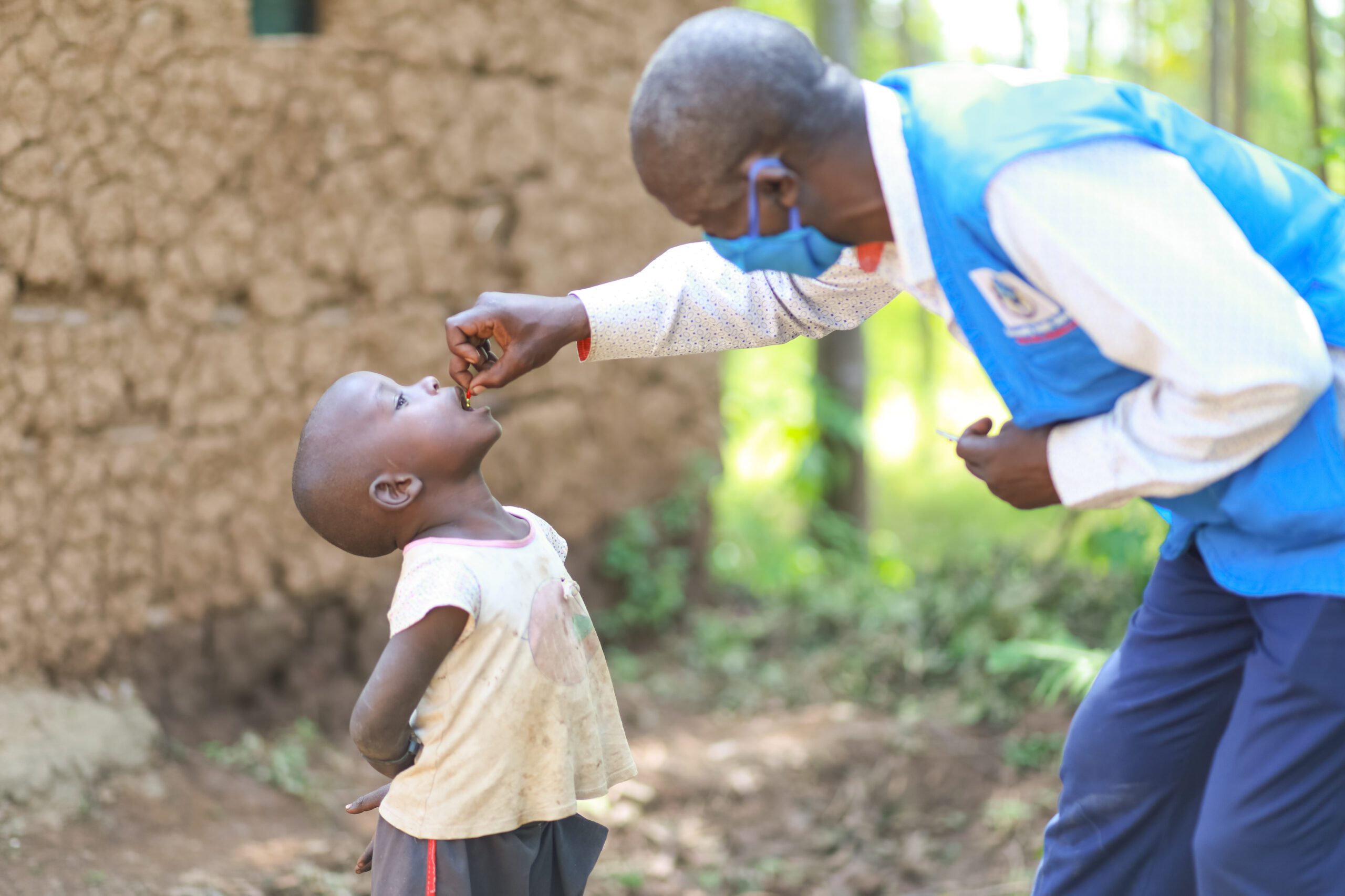 A health worker administers vitamin A drops to a child in Kenya