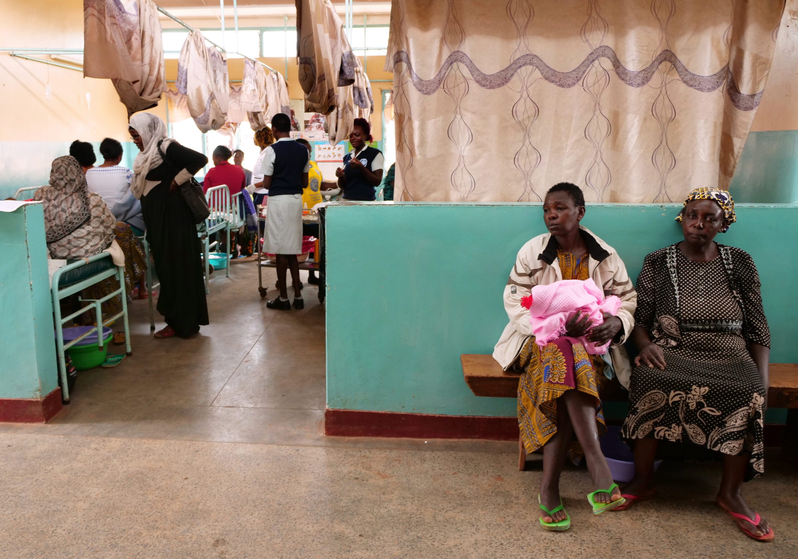 A mother sits with her newborn baby in the maternity care ward at Kitale County Referral Hospital.