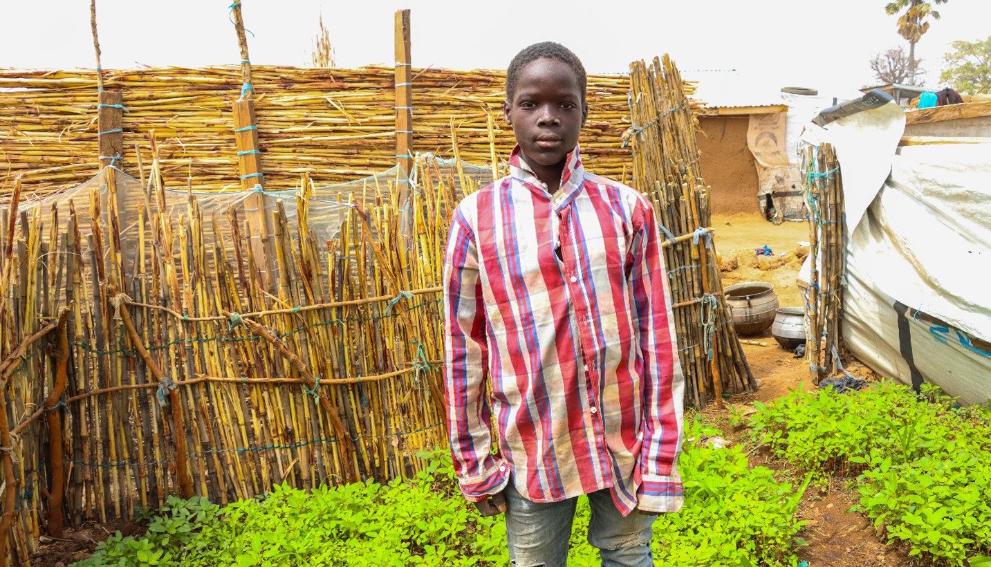 13-year-old Hamman standing in front of his garden.