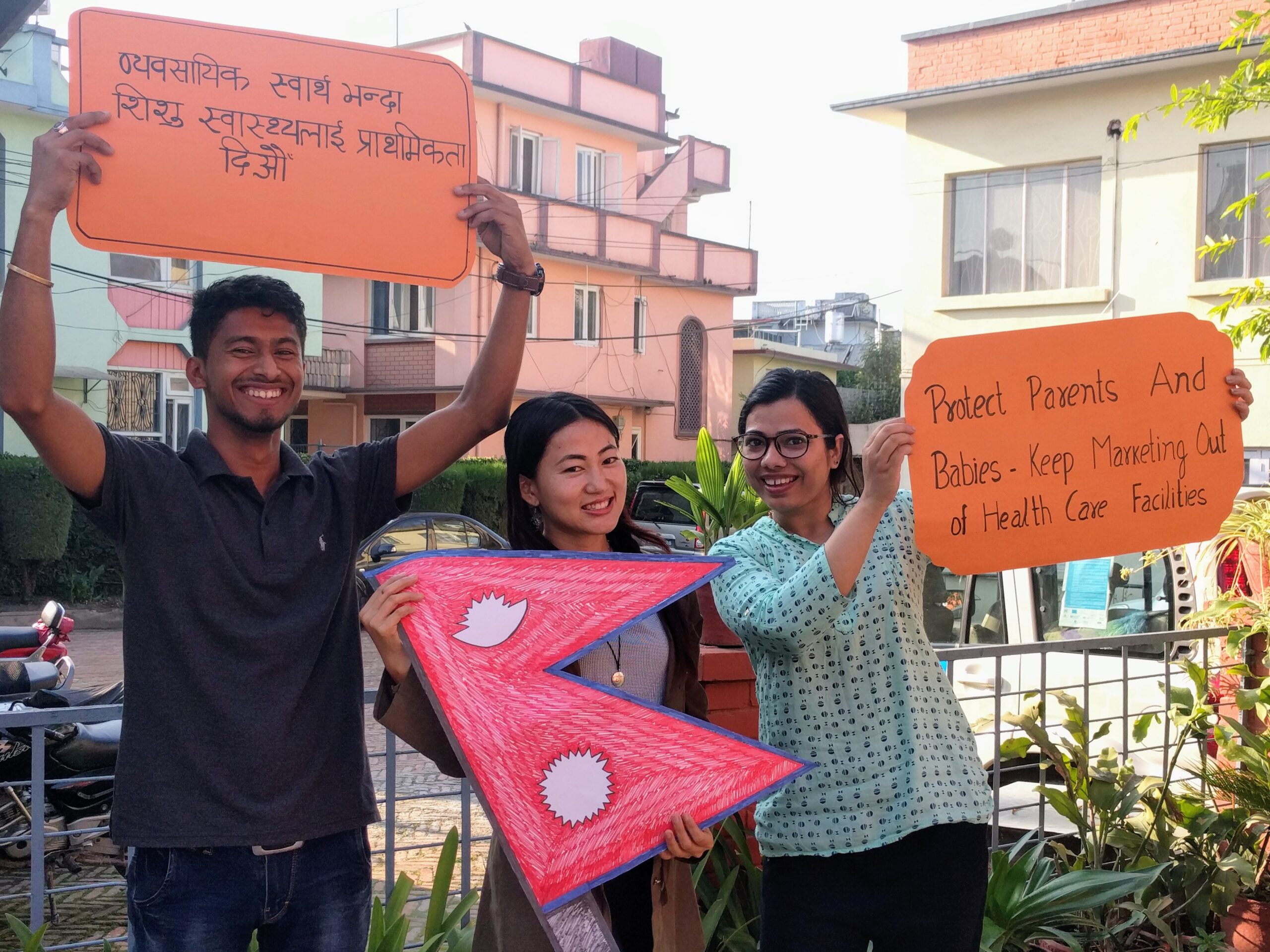 3 people holding signs