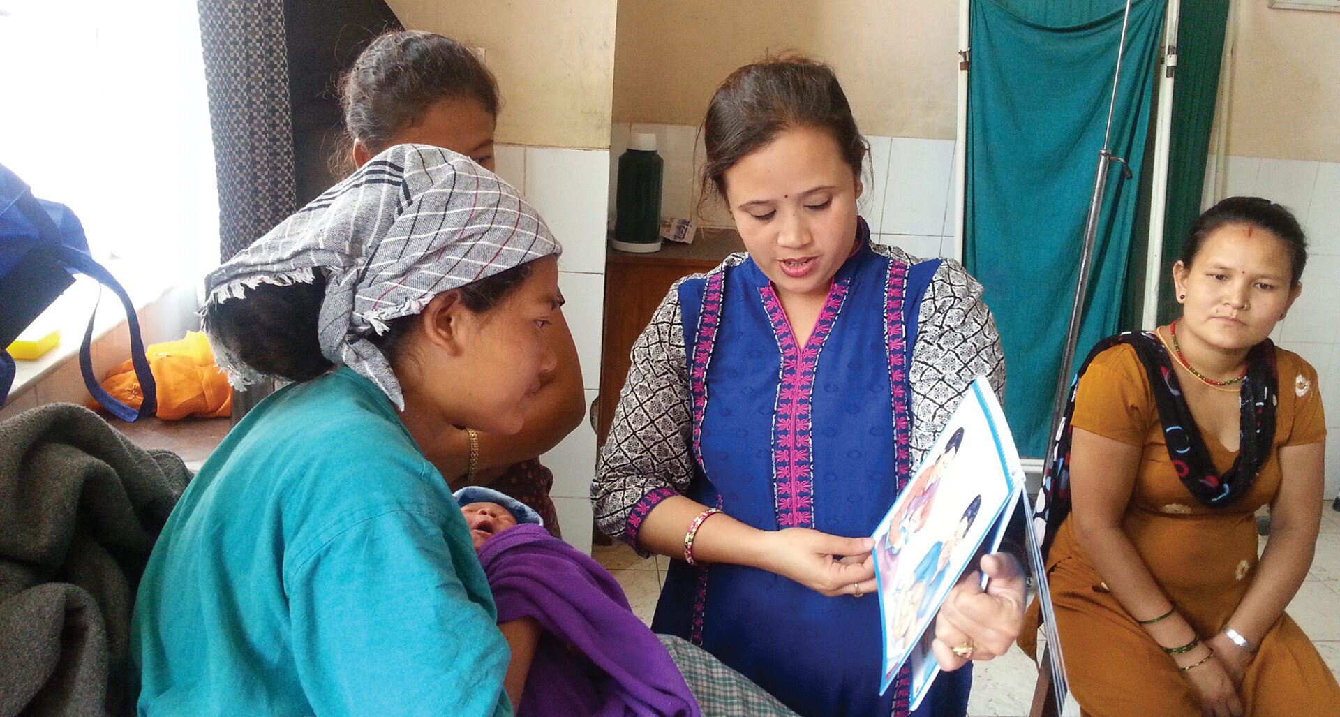 A health worker instructs a new mother on the best way to care for her new child.