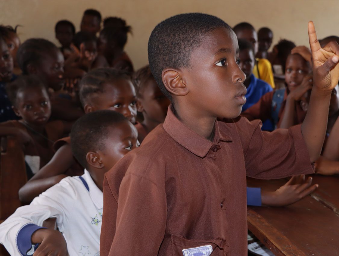 Male student in Cameroon raises his hand in class.