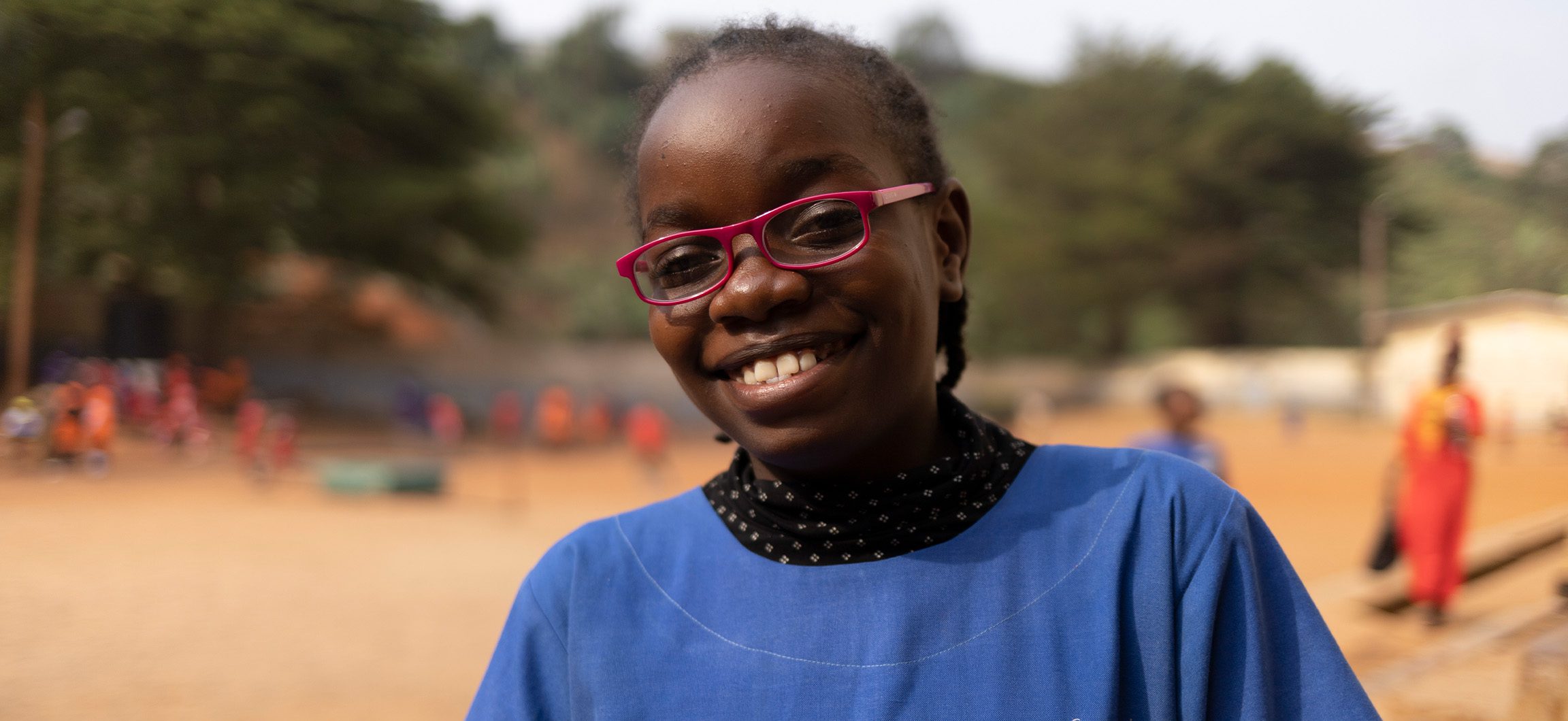 A little girl from Cameroon smiling wearing her new glasses.