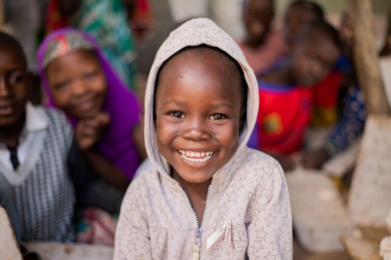 A young boy in Cameroon smiles for the camera.