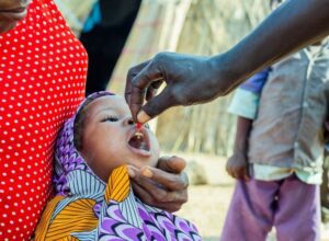 A close up of a young girl in Cameroon receiving a vitamin A supplement.