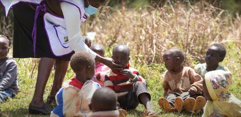 Health worker gives Vitamin A to children.