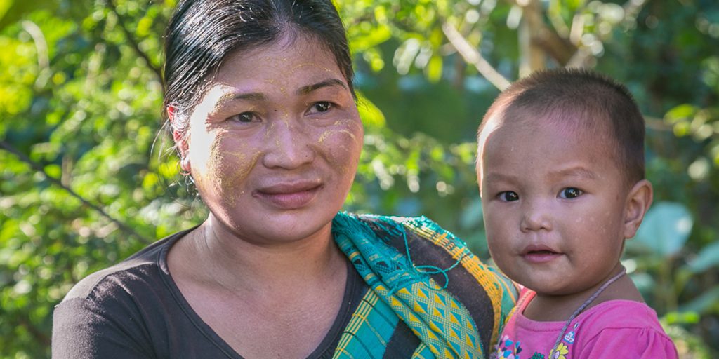 Mother and child smiling in green surroundings