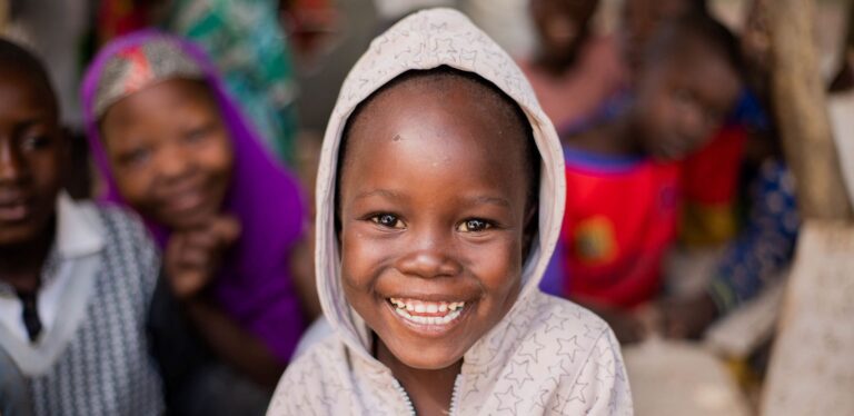 Happy child smiling with friends in background