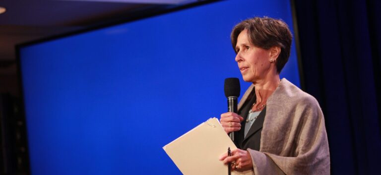 Woman speaking on stage with microphone