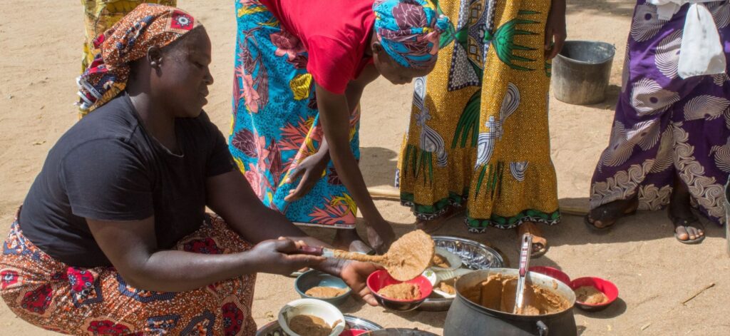 A Cameroonian woman spoons fortified pap into a bowl.