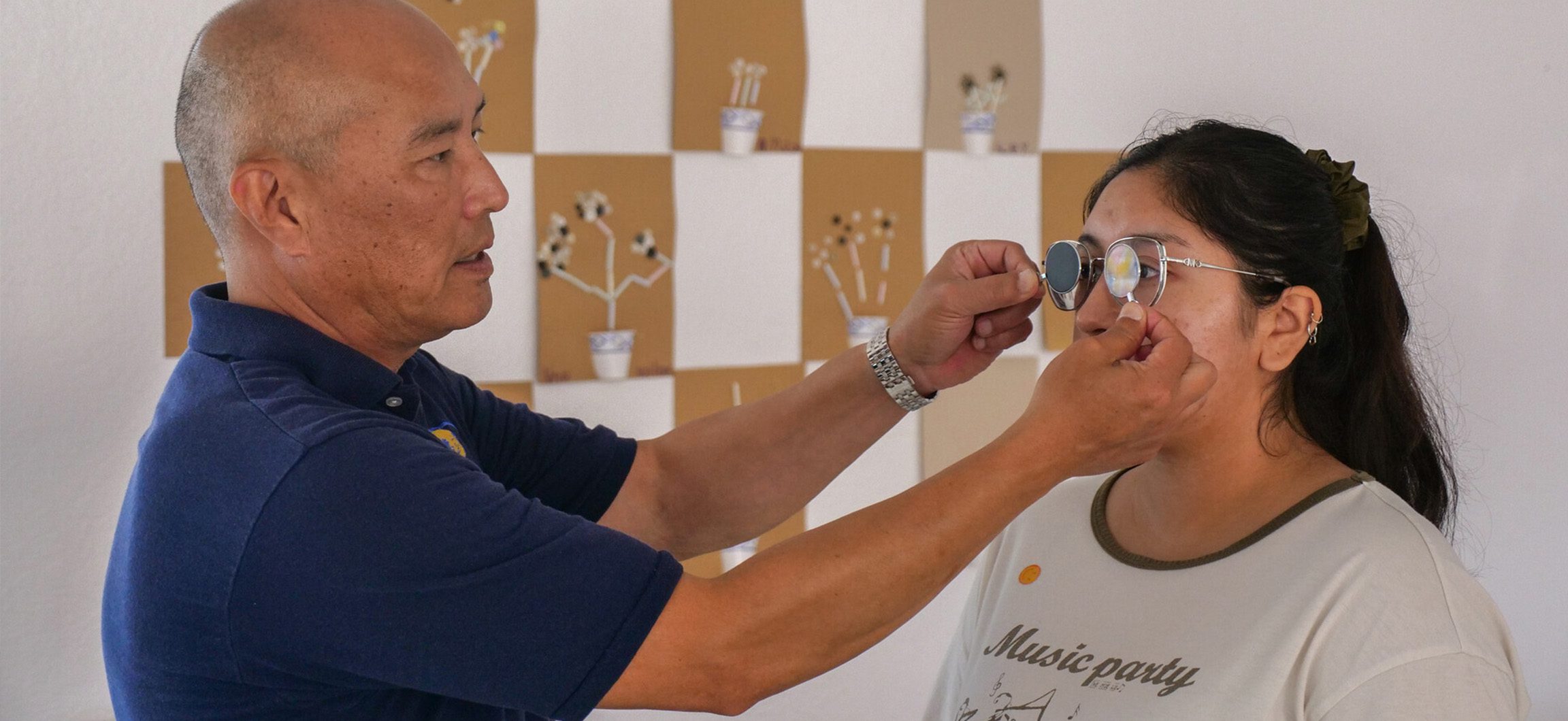 Optometrist screens young woman's eyes.