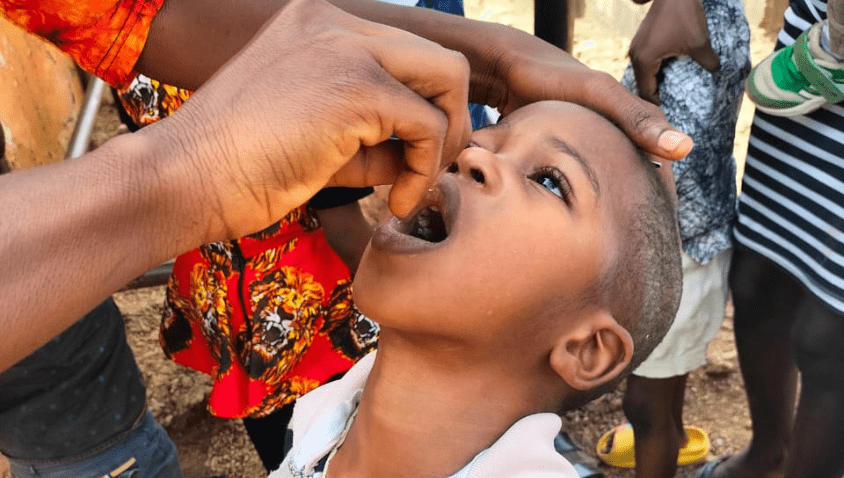 Child taking medication from adult’s hand