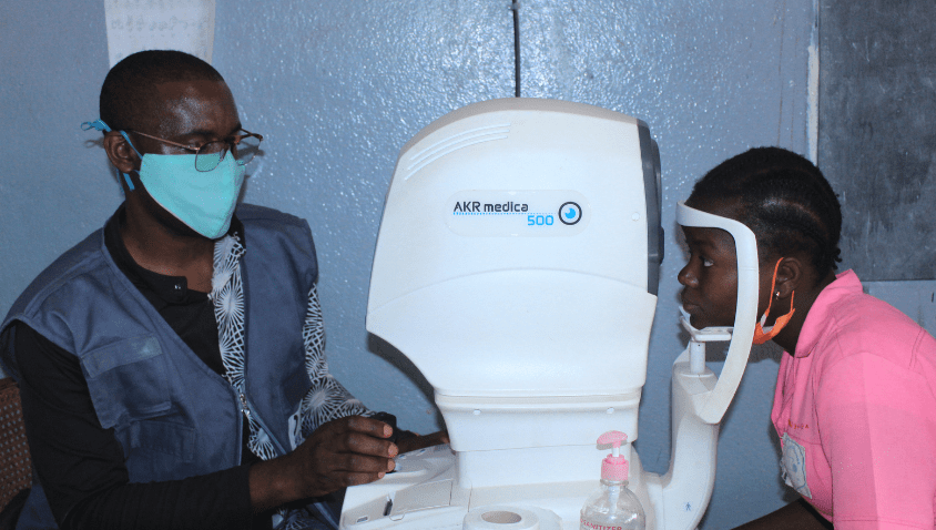 Woman having eye exam with healthcare worker.
