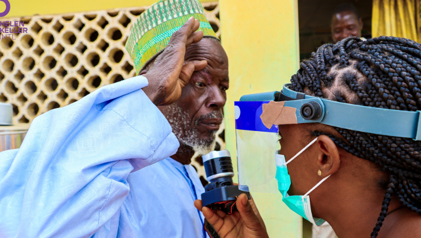 Surgeon examining elderly man's eyes for health.