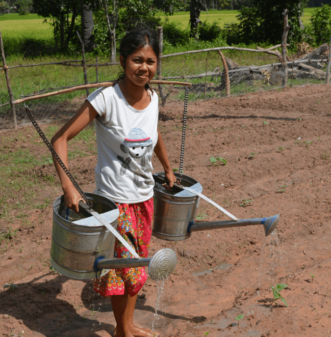Woman watering field with two cans