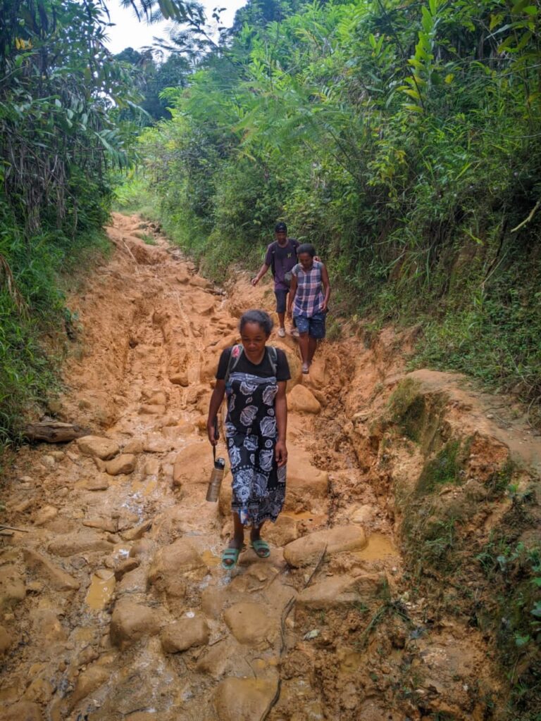 People trekking on a difficult, muddy trail