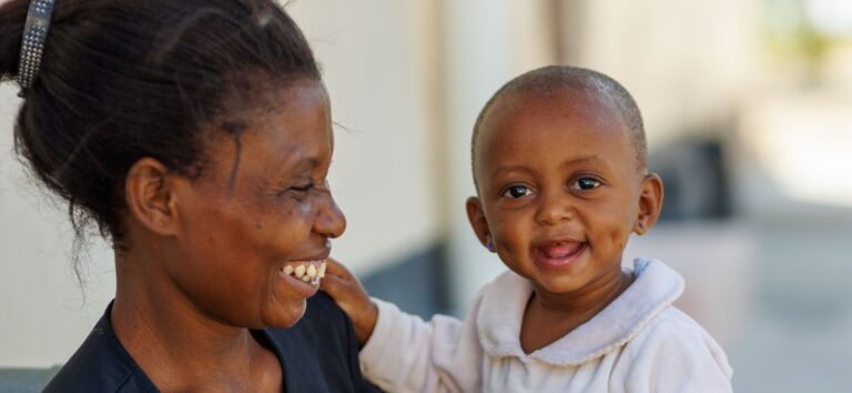 A Kenyan mother smiles at her baby.