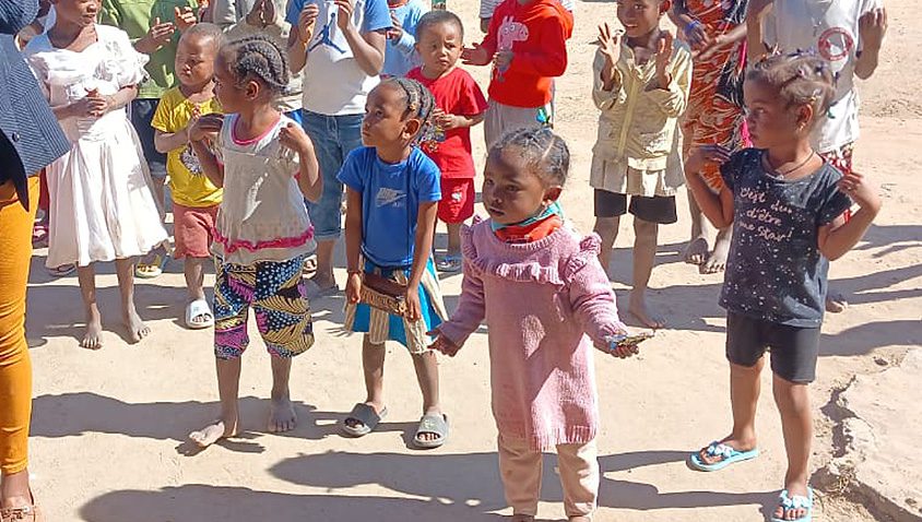 Rows of children clap their hands in celebration in Madagascar.