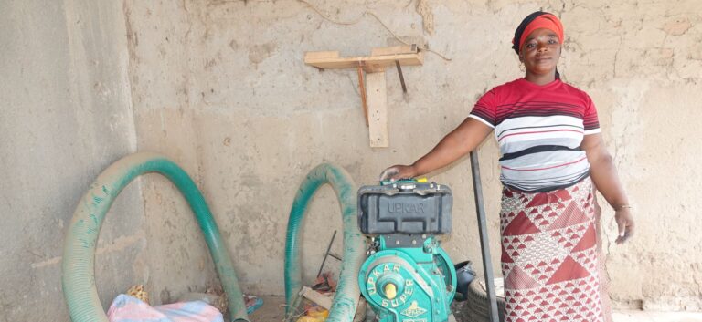 Woman with water pump in agricultural setting