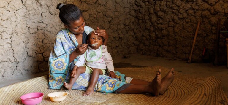 A woman in Kenya feeds her young daughter.