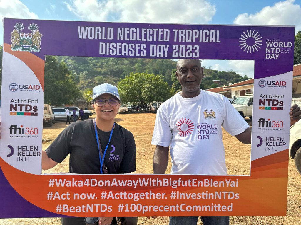 A woman and a man hold up a large photo frame for World Neglected Tropical Disease Day.
