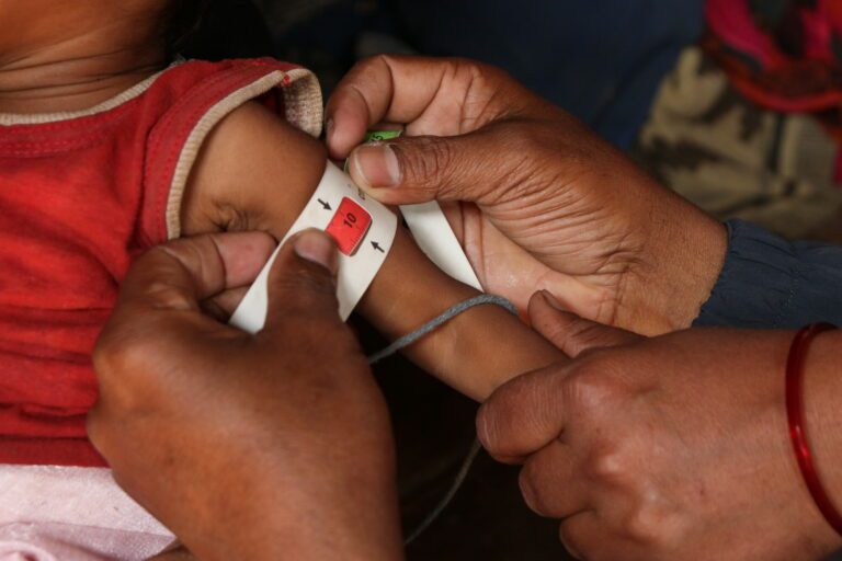 A Nepal baby being measured for malnutrition