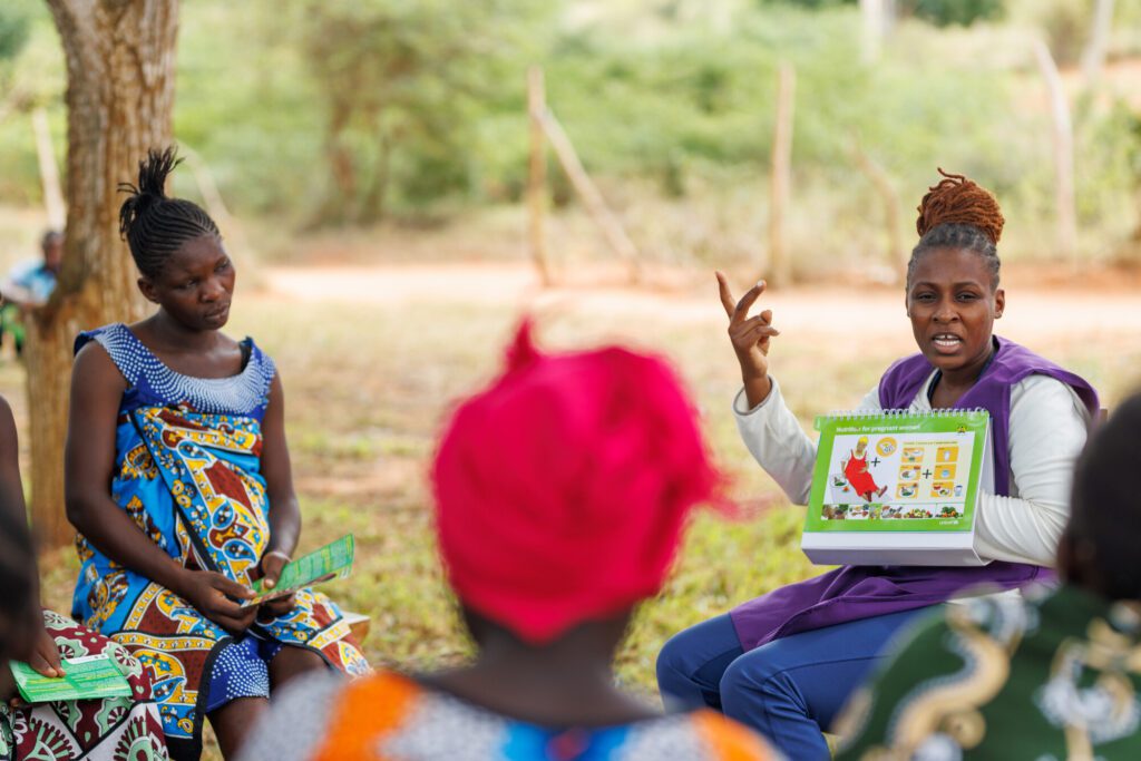 Woman presenting educational materials to a group.