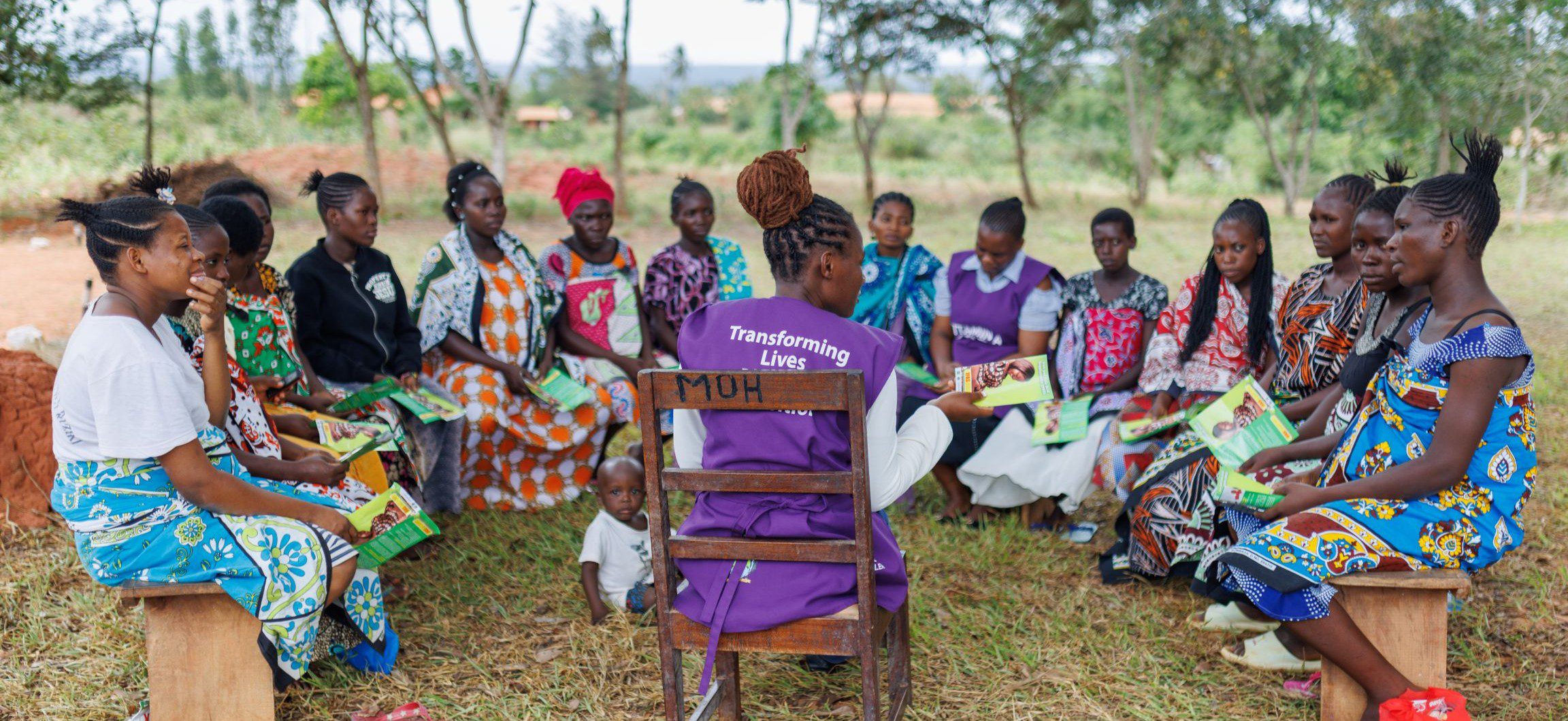 Women in colorful dresses at training session in Kenya.