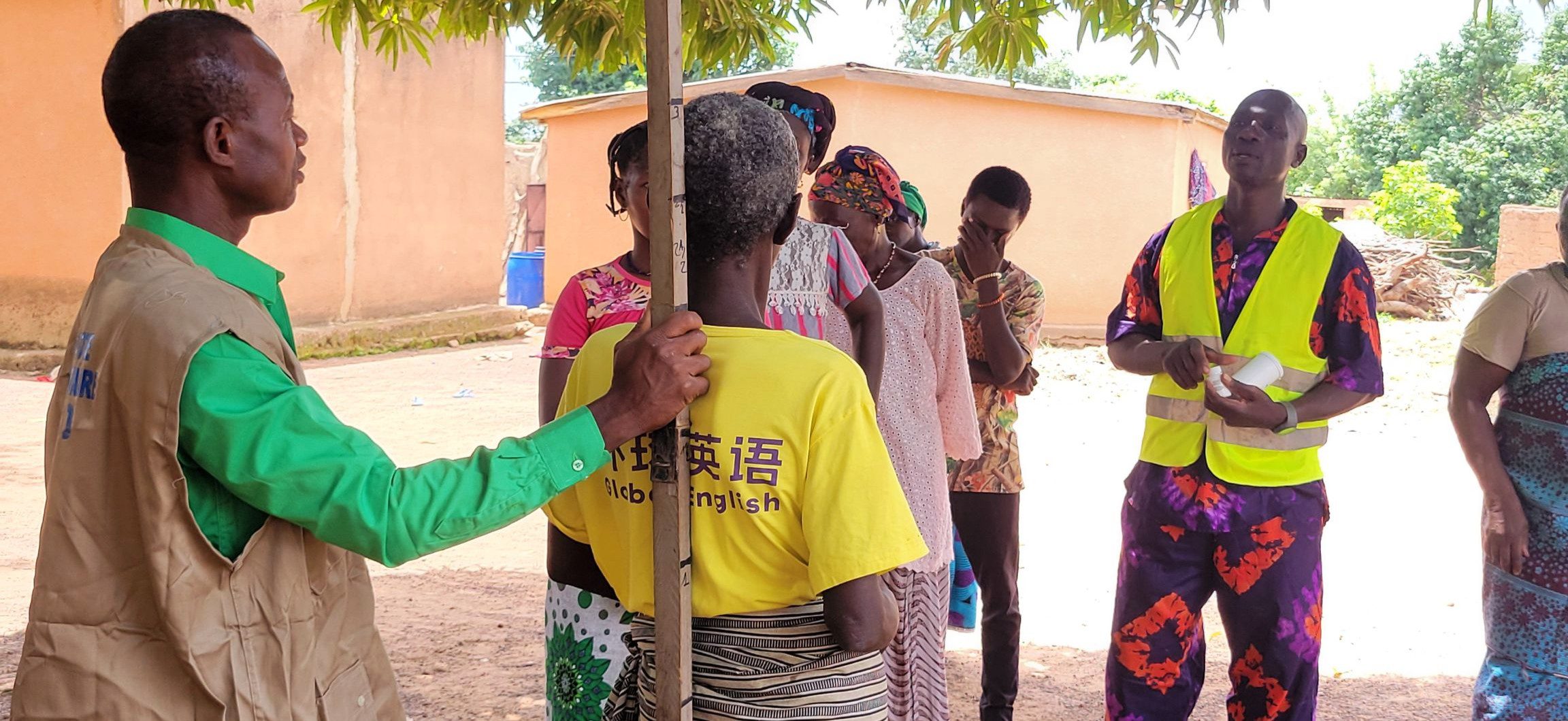 A woman has her height measured while others wait to receive medication for neglected tropical diseases in Burkina Faso.