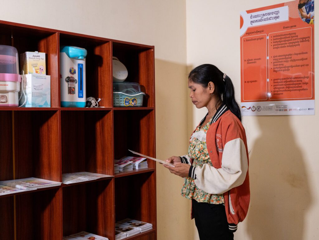 Woman reading pamphlet in lactation room in a factory in Cambodia.