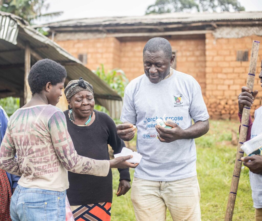 Man giving medicine to women outdoors