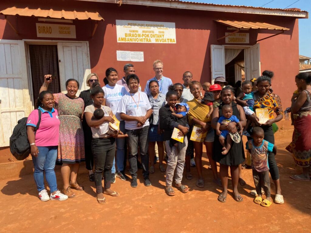 Mothers and children outside Madagascar community center