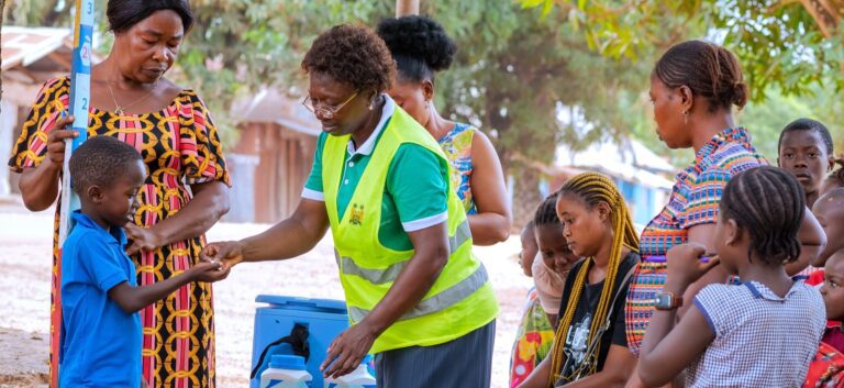 Healthcare worker gives preventive medication to a young boy outdoors