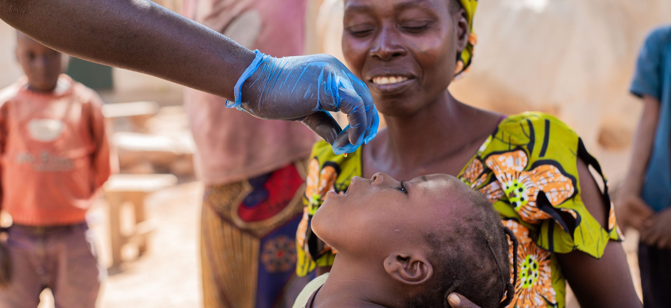 Child receiving vitamin A from healthcare worker