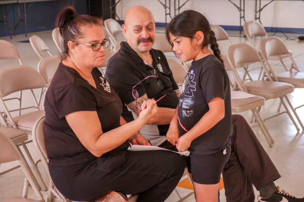 Woman showing glasses to smiling girl