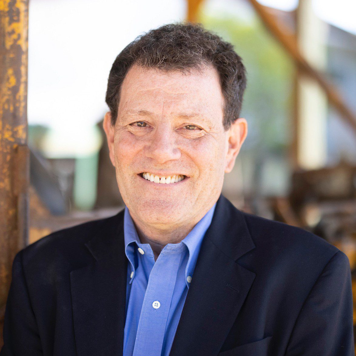 Smiling man in blue shirt and black jacket