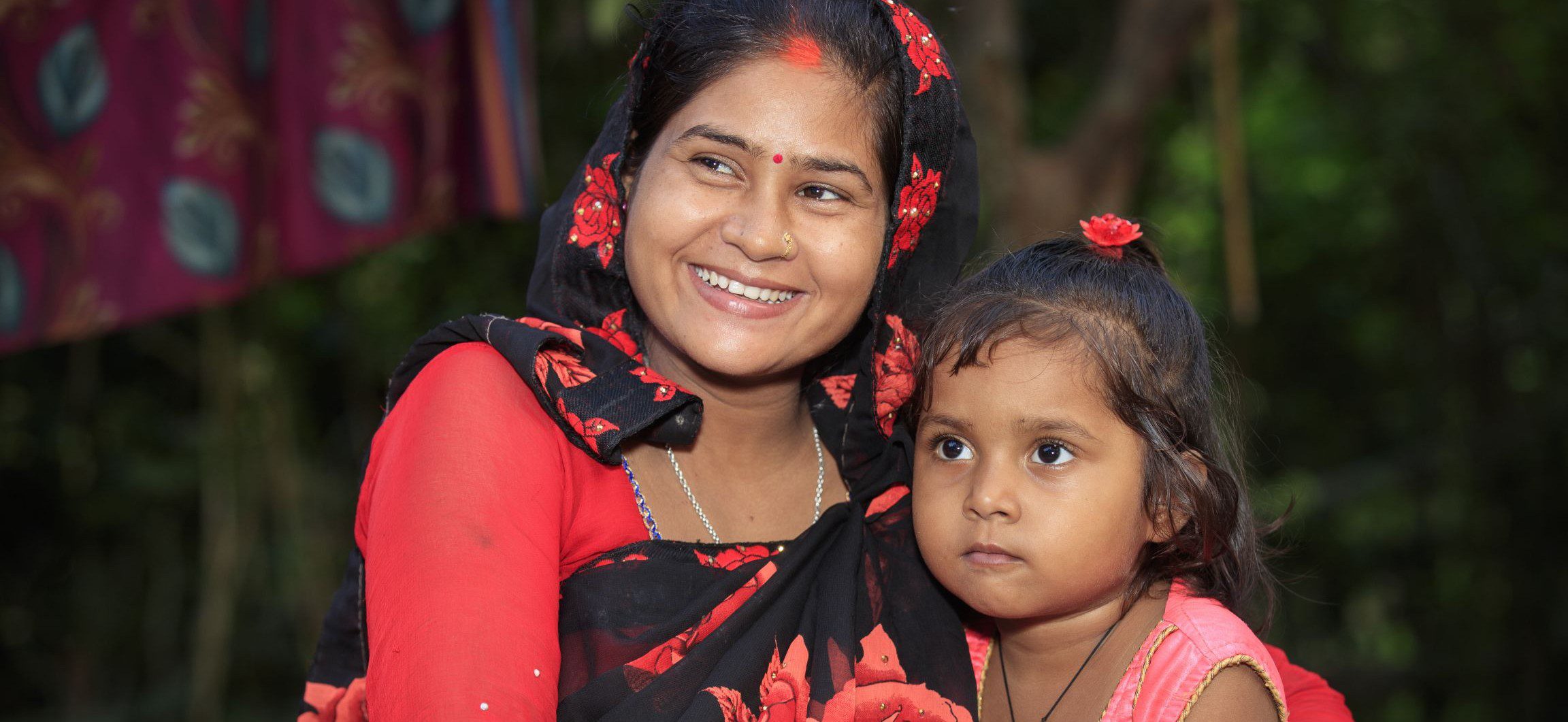 A mother in Nepal sits with her young daughter.