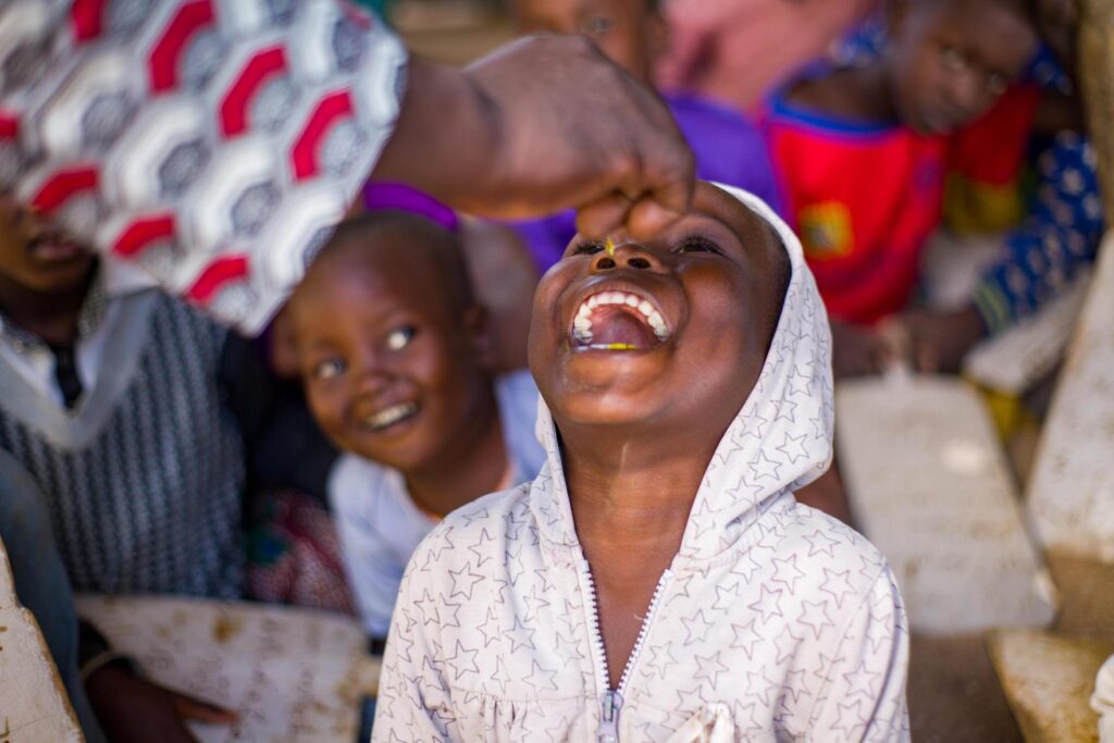 Child getting oral polio vaccine drops