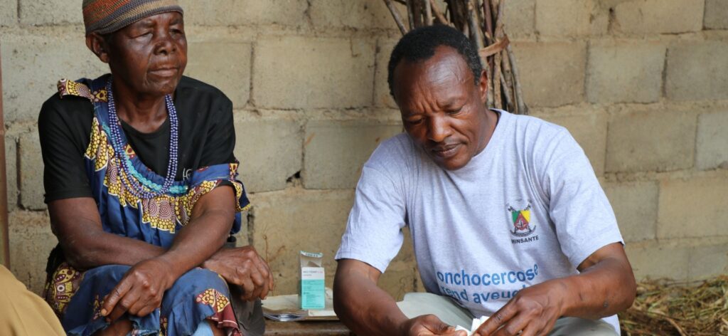 Health worker preparing medication for elderly woman