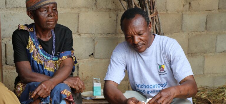 Health worker preparing medication for elderly woman