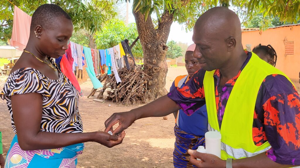 Man giving medicine to woman outside