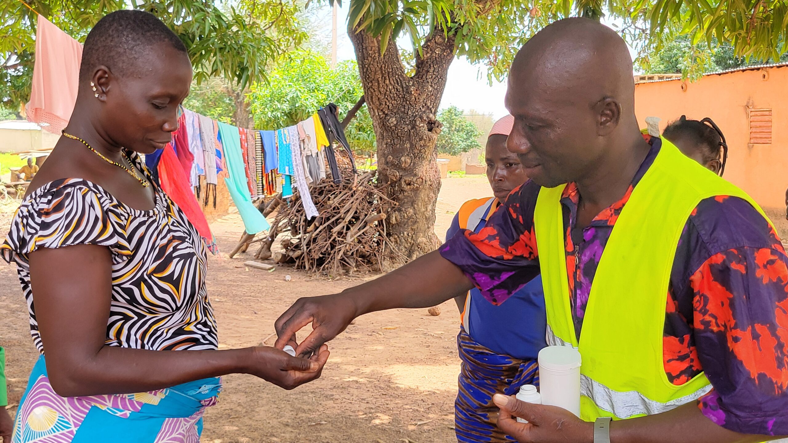 Man giving medicine to woman outside