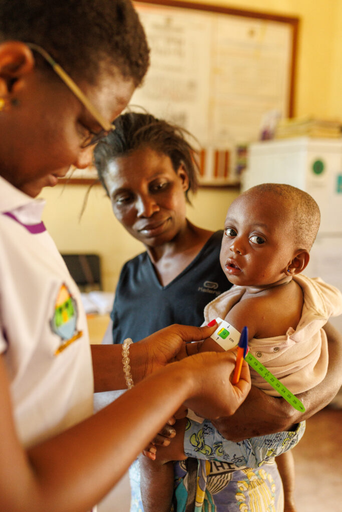Mother holds child while she is being examined by physician