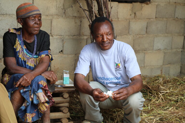 Healthcare worker giving medicine to elderly woman