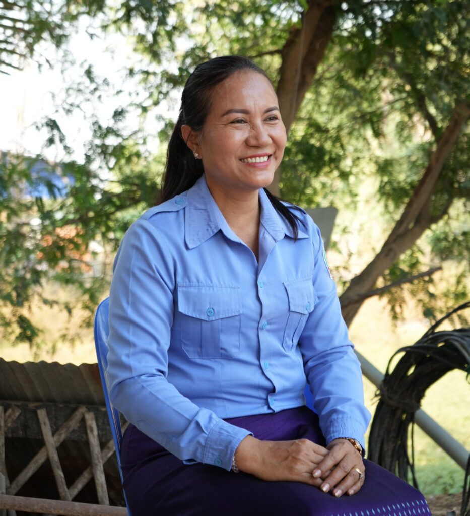 Woman smiling in blue uniform outdoors